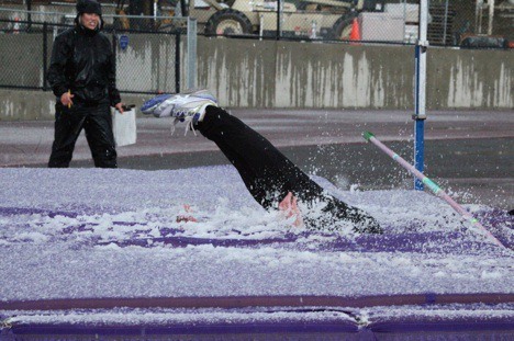 Issaquah high jumper Riley Foreman crashes into a hail-covered mat Thursday afternoon. She won the event with a leap of 4-feet-8 inches.