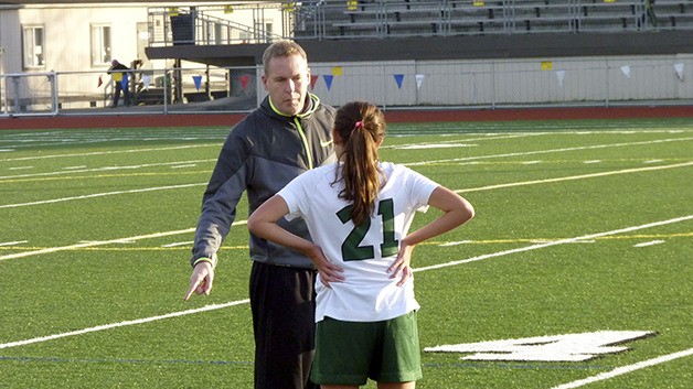 Marc Wilson discusses game strategy with one of his former players during a practice during the 2014 season.