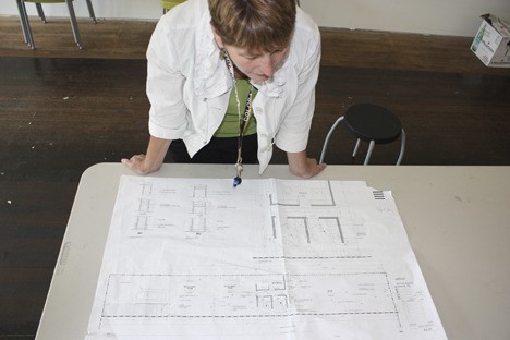 Karen Abel reviewing plans for the new artEAST store and studio.