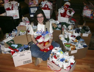 Claire Jones is surrounded by the 120 stockings collected in this year’s Girl Scout stocking drive.