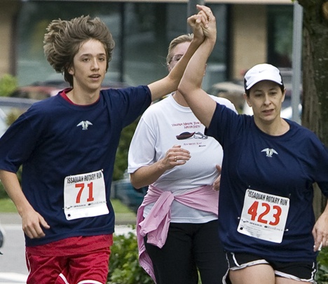 Jake Bolton raises Marnie Wagstaff's hand as they run down the final stretch of the 5K last year.