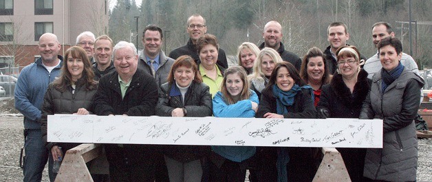 Participants in the Homewood Suites by Hillton stand by the beam that they signed to mark the topping off of the facility being built in Issaquah. Principals in the photo include Skip Rowley (second from left
