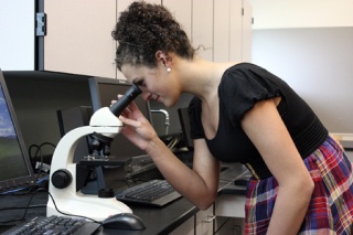 Eastside Catholic High School senior Jessica Terry peers into one of the microscopes she used to confirm her diagnosis of Crohn's Disease.