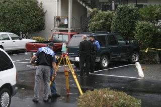 Officers work with the Total Station survey tool at the scene of an assault investigation at the Overbrook Apartment complex at the intersection of Newport Way Southwest and West Sunset Way. The assault occurred at about 2 a.m. Oct. 3.