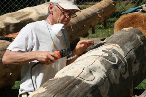 Milenko carving a pattern into salvaged cedar tree for the Pacific Connections Garden shelter at the Washington Park Arboretum.