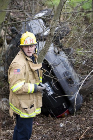 An Eastside Fire and Rescue member checks a car which went over an embankment Wednesday afternoon.