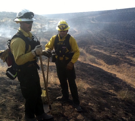 Eastside Fire and Rescue Firefighters Rick Scriven and Michael Tjosvold conduct mop up operations at a fire in Dead Canyon