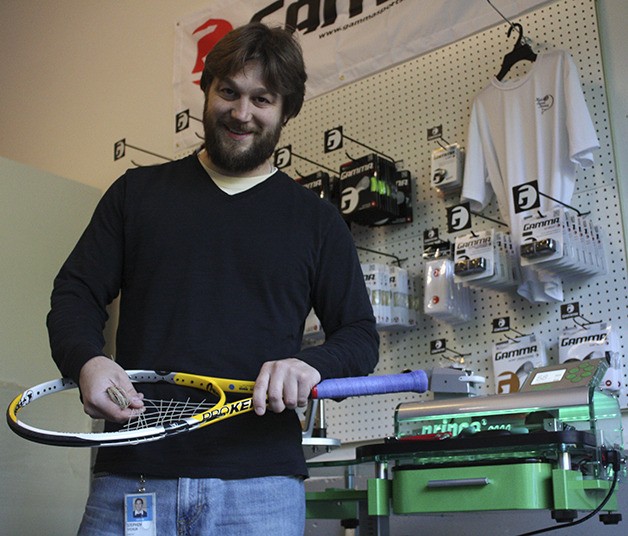 Stephen Stchur takes the old strings out of a tennis racquet near his Prince 6000 stringing machine in his garage workshop in Carnation. Stchur recently relocated from Sammamish
