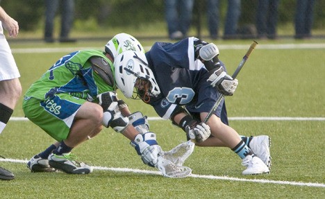 IYL Rainier midfielder and face-off specialist Mikey Giannopulos (right) battles for control of the ball in  the opening faceoff of the Senior Division Championship game.