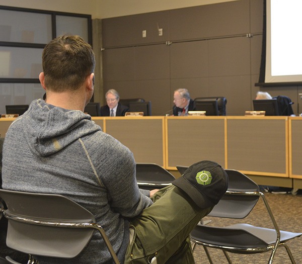 An Eastside Fire and Rescue fire fighter sits in the front of the Sammamish City Hall chambers Tuesday night