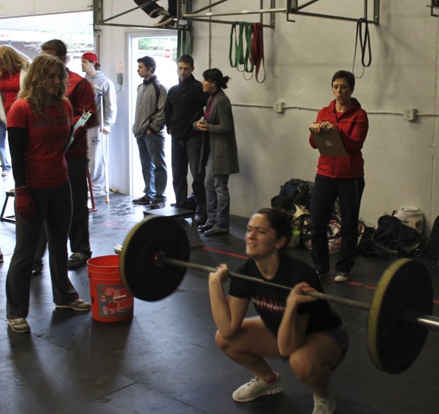 Rachael Mitchell performs a workout under the watchful eye of judges during a CrossFit competition.