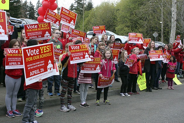 At least 100 people lined 216th Avenue outside of Mead Elementary Tuesday morning. The crowd waved red signs that urged passers-by and drivers to “Vote YES” on the Lake Washington School District’s $398 million bond to rebuild and enlarge Mead Elementary