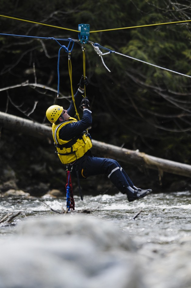 An Eastside Fire and Rescue firefighter practices using a line to cross a river safely.