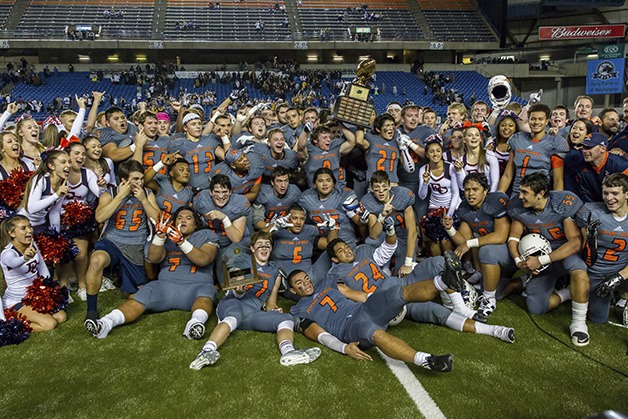 The Eastside Catholic Crusaders football team celebrates after defeating the Bellevue Wolverines 35-13 in the Class 3A state football championship game this past December at the Tacoma Dome. The Crusaders are looking to repeat as champs on the gridiron this fall.