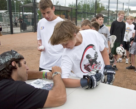 Josh Bean get his shirt autographed by Paul Rabil while brother Nate Bean looks on.