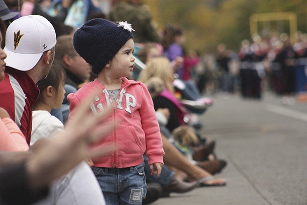A girl watches Salmon Days from the shoulder of Front Street.