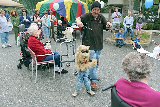 Providence Marianwood resident Barbara Wentz and other residents and family members enjoy watching puppeteer James Blankmeyer of “Strings Attached” entertain guests at Marianwood’s Summer Celebration picnic Aug. 13 at the nonprofit nursing home in Issaquah. The facility celebrated 25 years of serving local residents.