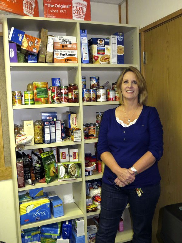 Tiger Mountain Community High School educational assistant Tammy Anderson stands in front of the food pantry they keep at the school for students in need.