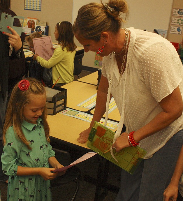 Aryanna Salinas asks first grade teacher Kelly Gapinski about some of the items on a scavenger hunt list.