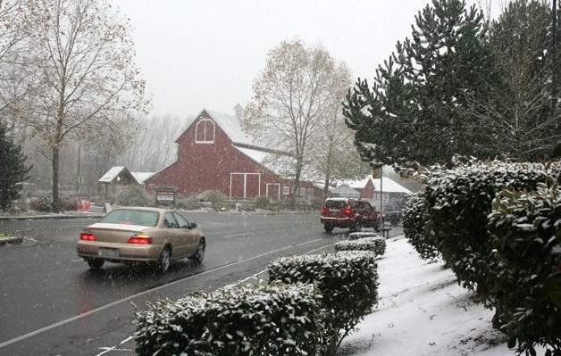 Snow falls on the Pickering Barn near Costco in Issaquah Monday. Winter weather brought frigid temperatures and the white stuff early in the week.