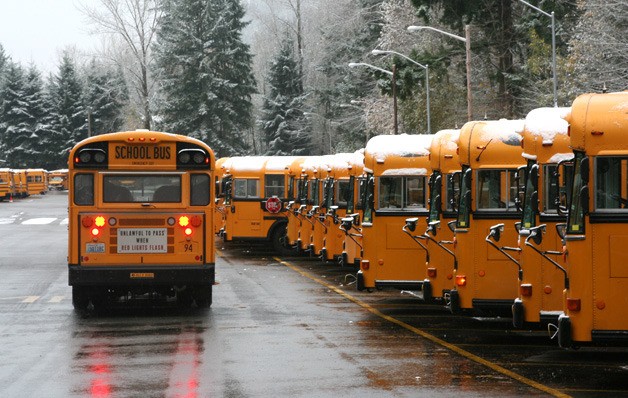 Snow dusts the top of Issaquah School District buses at the bus barn near Issaquah High School. High school and middle school students were taken home an hour early to ensure the bus drivers could make it back in time to bring home the elementary students.