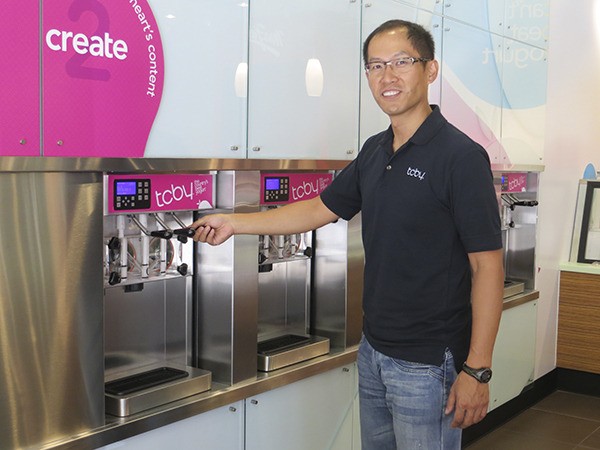 Jeffrey Chang demonstrates how the serve yourself frozen yogurt on-tap works at the new TCBY in the Issaquah Highlands.
