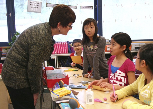 Fifth-grade students in the MERLIN program discuss Colonial Boston projects with teacher Kim Ralph. From the left