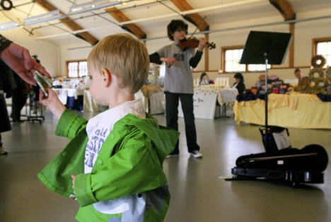 Toddler Andrew Thomas relays tips to violinist Evan Hjort