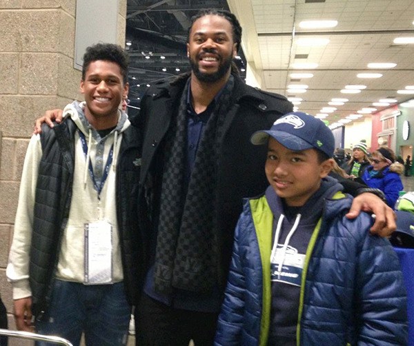 Rey Daoed (right) from Pine Lake Middle School and Ivory Randle (left) of Skyline High School pose with former Seahawk Sidney Rice Nov. 29.