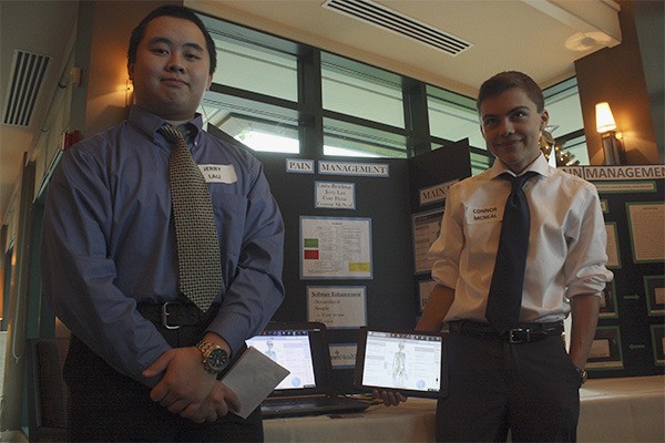 Eastlake High School seniors Jerry Lau and Connor McNeal display their solution to EvergreenHealth’s need for a pain management education tool. McNeal holds a tablet that runs the program he and his team created for nurses to use.