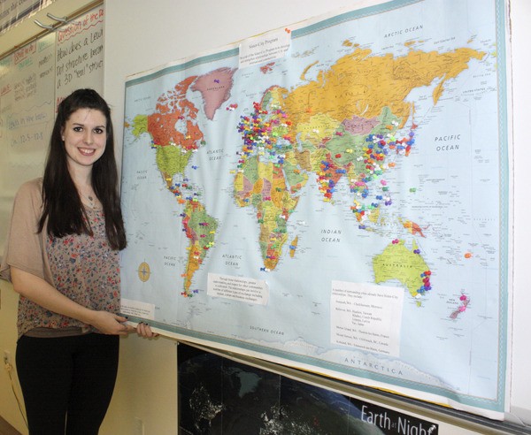 Eastlake senior Rachael Martel stands with a poster she used last summer during Sammamish Days. She asked residents to plot where they are from or where they have traveled in the world to help give her ideas for her sister city project.