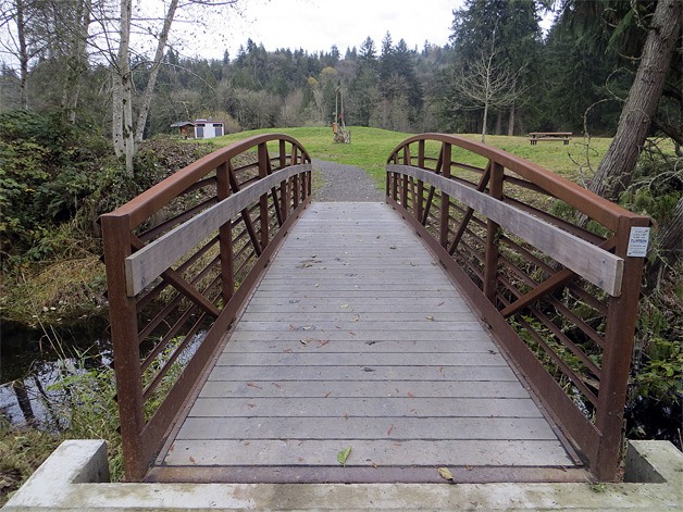 The bridge over the creek leads to open fields with trails