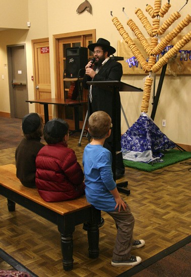 Rabbi Berry Farkash presents a donut menorah to the Jewish community in Issaquah for Hannukah.