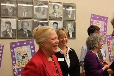 Former Issaquah School Board member Connie Fletcher stands in front of a display of former school board members during her farewell celebration.