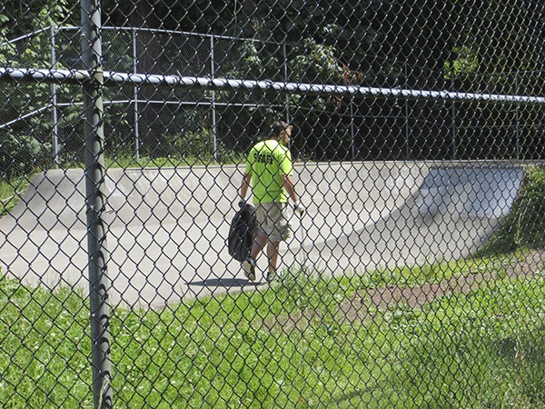 A city worker picks up trash at the Issaquah Skateboard Park.