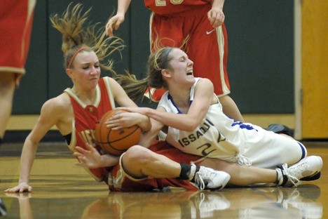 Newport guard Caitlin Bennett and Issaquah guard Blaire Brady hit the floor for a loose ball during a game played at Eastlake High School on Friday. Issaquah won 56-34