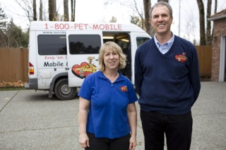 Groomer Michele Schuman and owner Leon Feuerberg pose in front of one of the mobile grooming salons.