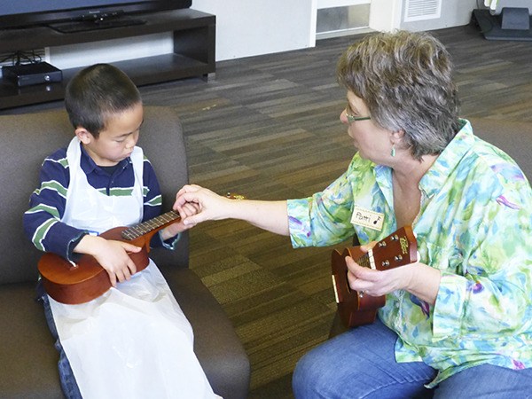 A student learns how to play the ukelele at the 'Au-Some Artists!' event on April 26.