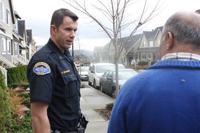 Issaquah Police Commander Scott Behrbaum speaks with resident T.K. Panni about speeding on NE Park Drive last November.