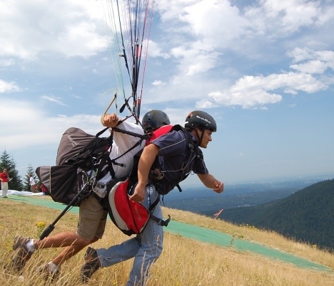 A Northwest Paragliding Club instructor prepares to give one brave local the ride of his life