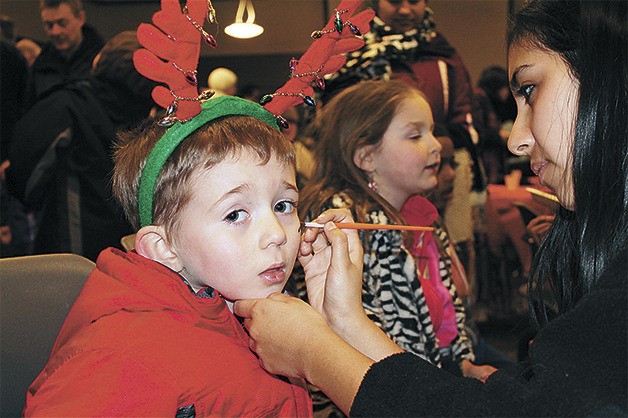 A young attendee of 'Very Merry Sammamish' in 2013 has his face painted. Visitors can also meet the Ice Queen