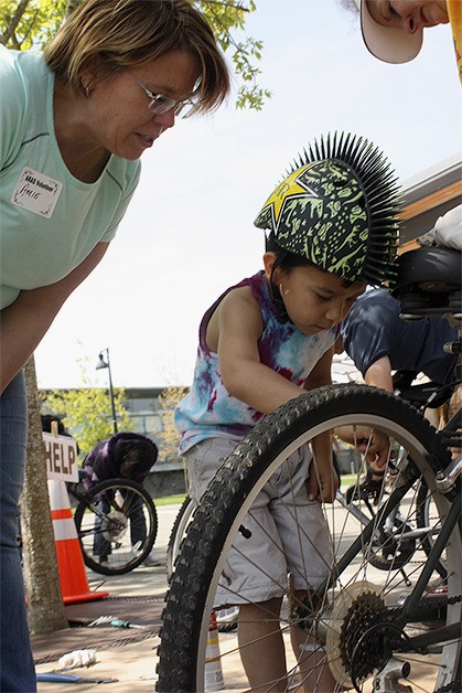 Five-year-old Tony Santerelli loosens the breaks on a bicycle to be shipped to Ghana