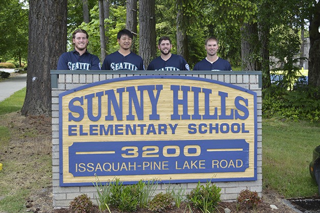Mariners players pose at the Sunny Side Elementary School sign.