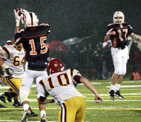 Connor McCormick watches through the raindrops as receiver Blake Tamminen reels in a pass Friday against O'Dea.