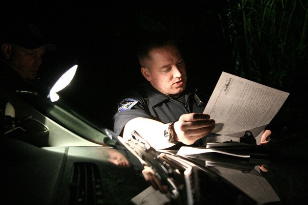Officer Nathan Lane fills out a witness statement in a domestic violence incident on the hood of his patrol car. DV cases are some of the most dangerous for officers.