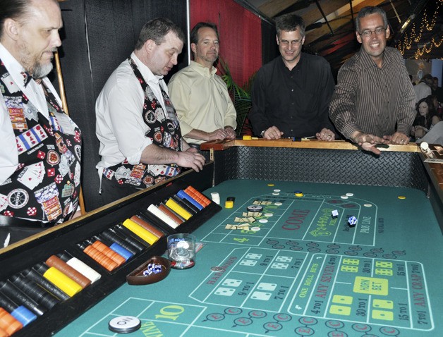 Issaquah resident Ron Gregerson rolls the dice for a good cause at the recent Encompass Casino Night fundraiser at Pickering Barn in Issaquah.