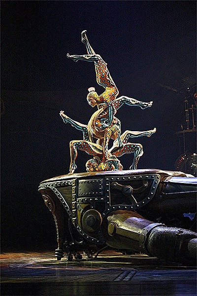 Four deep-sea creatures that embody electric eels inside the Seeker’s cabinet come to life in a contortion act. The wriggling artists execute a series of pyramids using the Mechanical Hand as a platform.