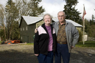 Helen and Donovan Albrecht stand in front of a historic barn on their property
