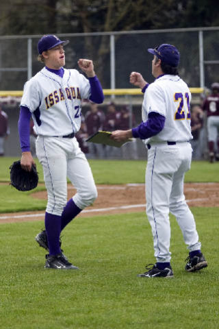 Issaquah senior Tyler Vanderboegh is congratulated by assistant coach Steve Sanelli after striking out the final batter of the second inning against Mercer Island.