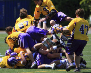 Members of the Issaquah lacrosse club team pile on one another after winning the Division I state championship Saturday in Seattle.